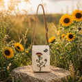 Boho floral crossbody phone pouch with embroidered flower design displayed in a sunflower garden setting