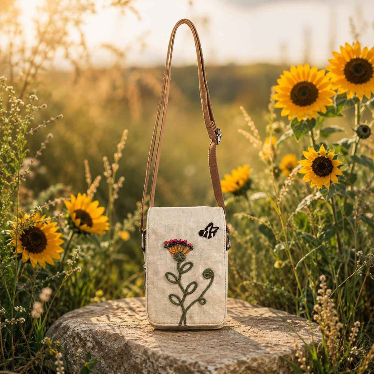 Boho floral crossbody phone pouch with embroidered flower design displayed in a sunflower garden setting
