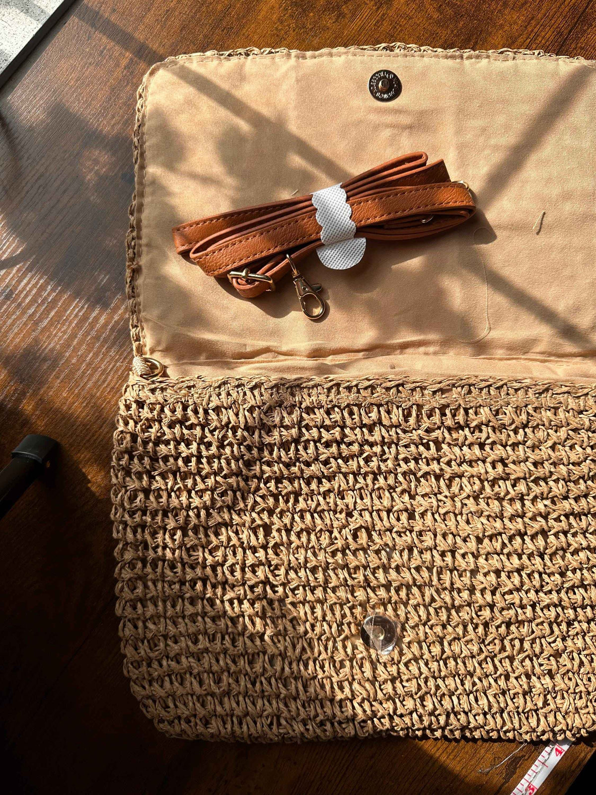 Interior view of vintage granny square straw purse with woven lining and secure magnetic button closure
