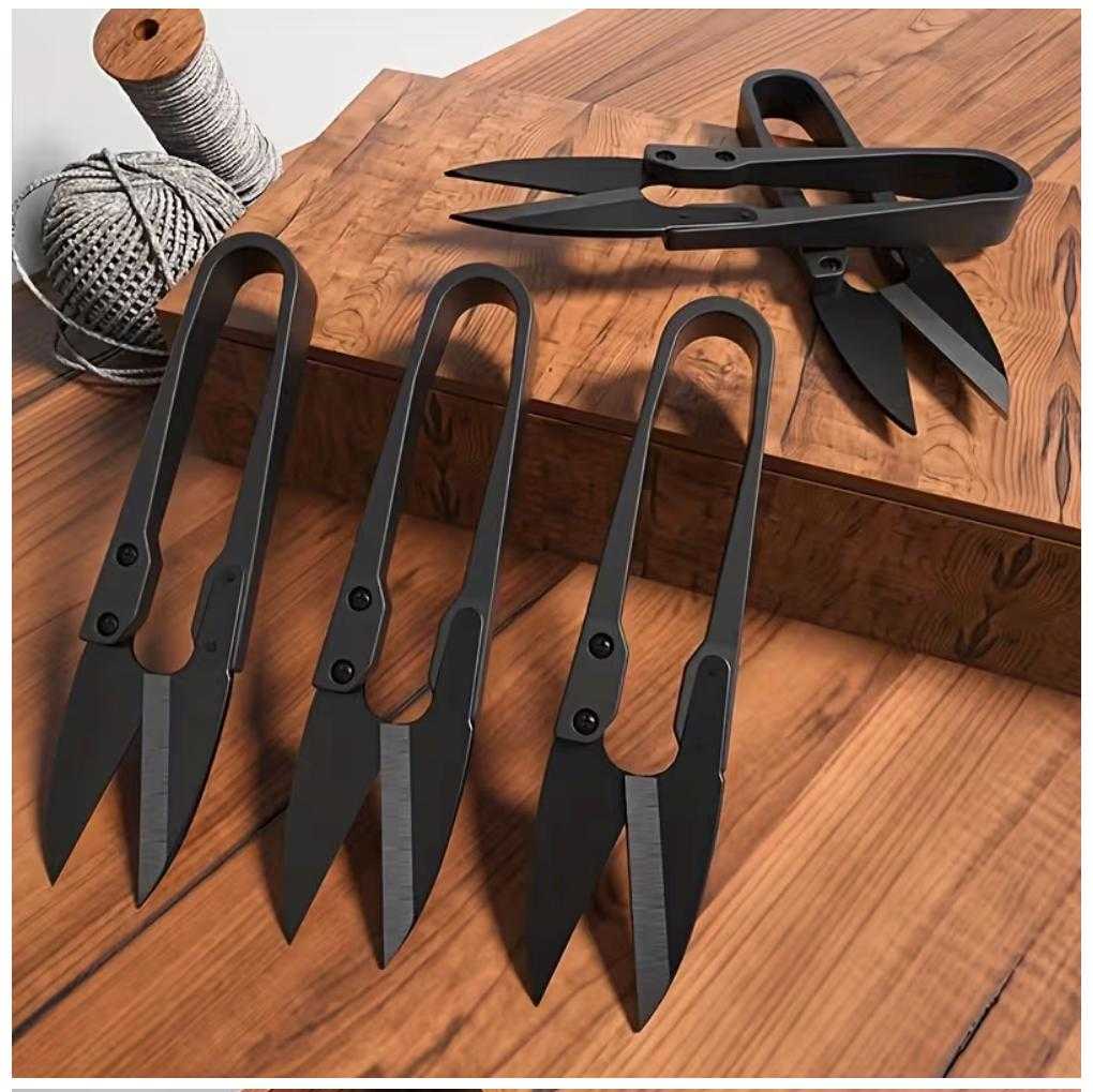 Set of black U-shape embroidery scissors arranged on wooden table for sewing, quilting, and needlework use