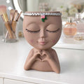 Decorative makeup brush holder featuring a modern face planter design for vanity organization and home décor