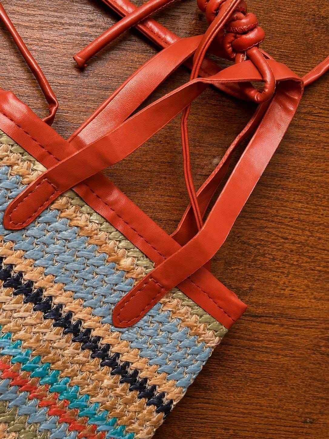 Detail of leather strap and woven straw design on colorful summer crossbody bag