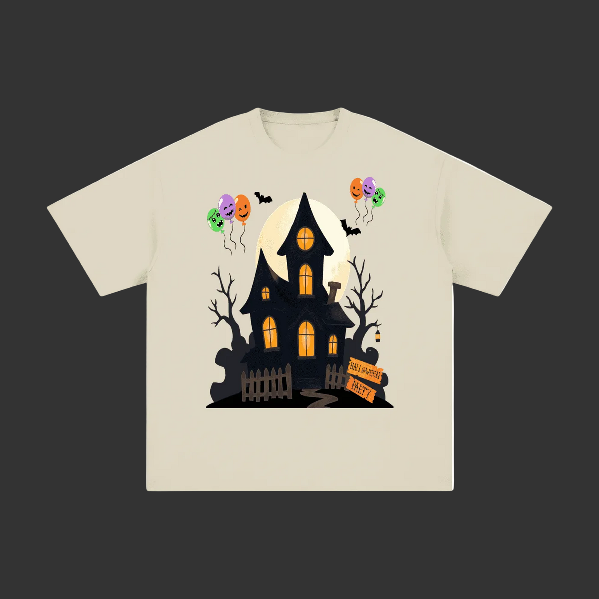 A light beige crewneck t-shirt featuring a graphic print of a spooky haunted house at night with jack-o'-lantern balloons, bare trees, and a full moon.