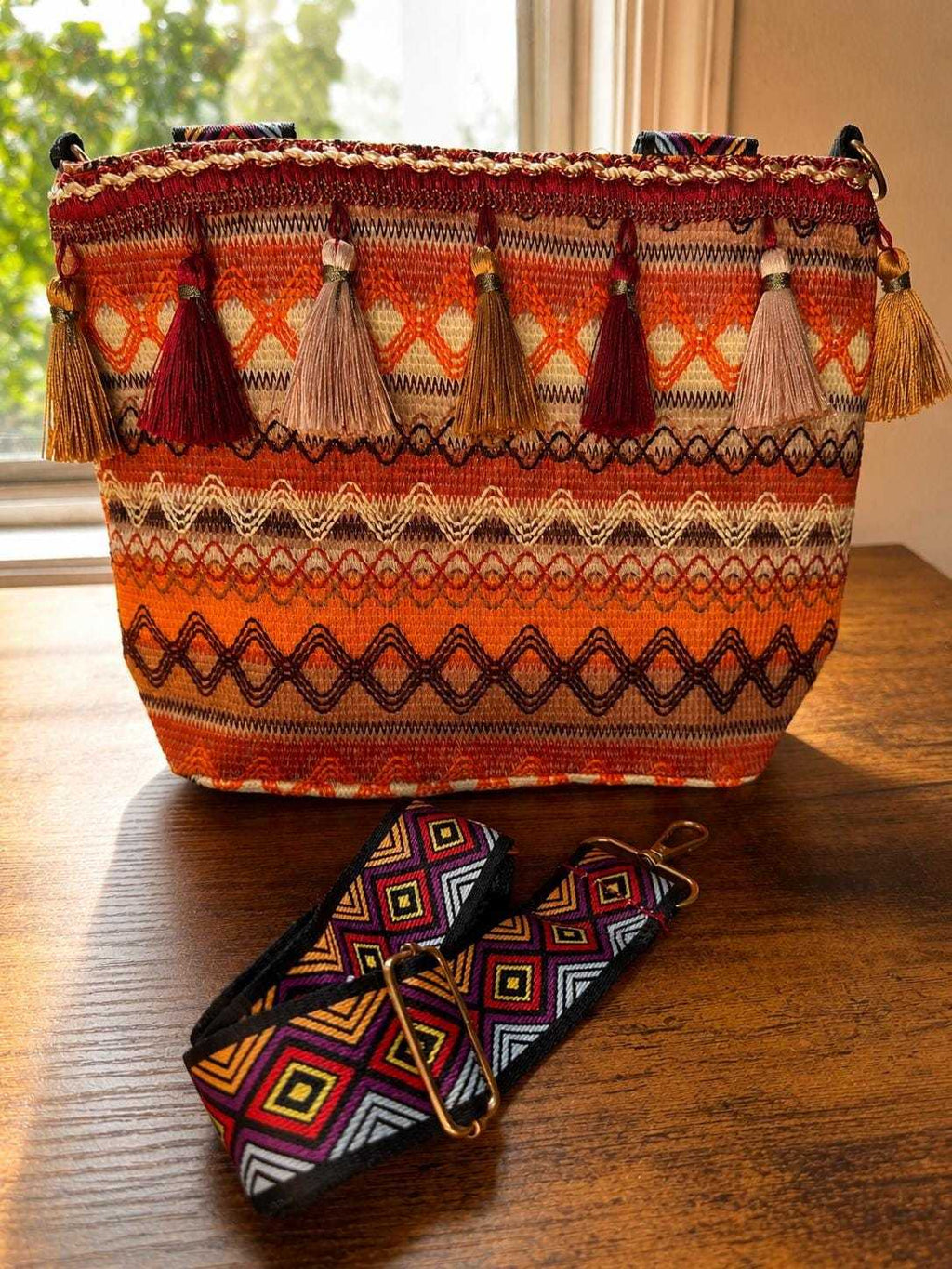 Patterned woven shoulder bag with tassels and adjustable strap