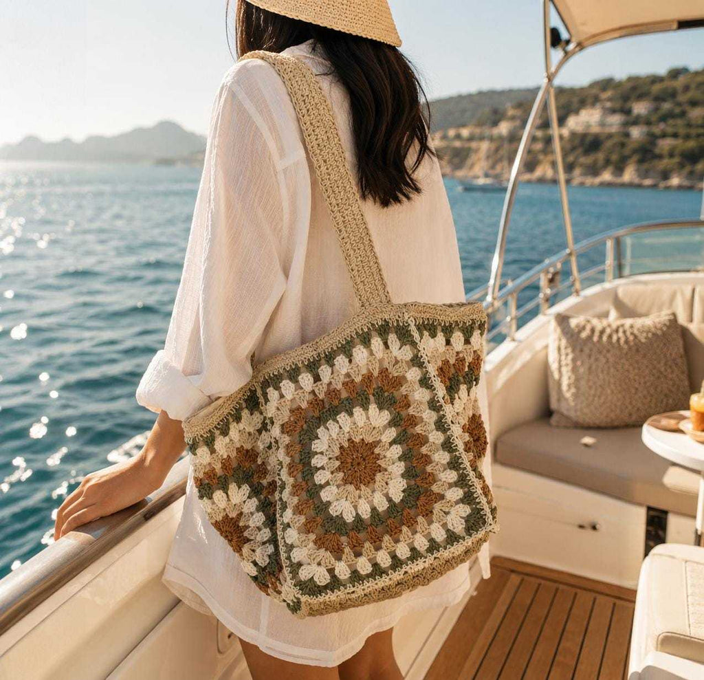 Woman carrying boho crochet tote bag with woven granny square pattern on a yacht by the sea