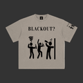 A light gray crewneck t-shirt with a black graphic print on the front reading 'BLACKOUT?' above three stick figures, with a matching sleeve print, shown on a plain gray background.