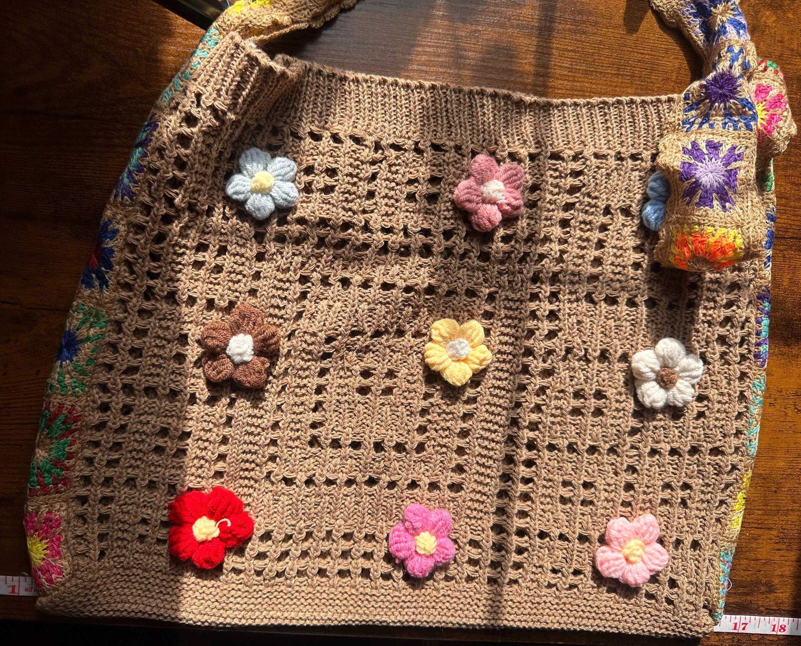 Handmade crochet tote bag with colorful floral appliqués, boho-inspired design, and spacious open-weave construction