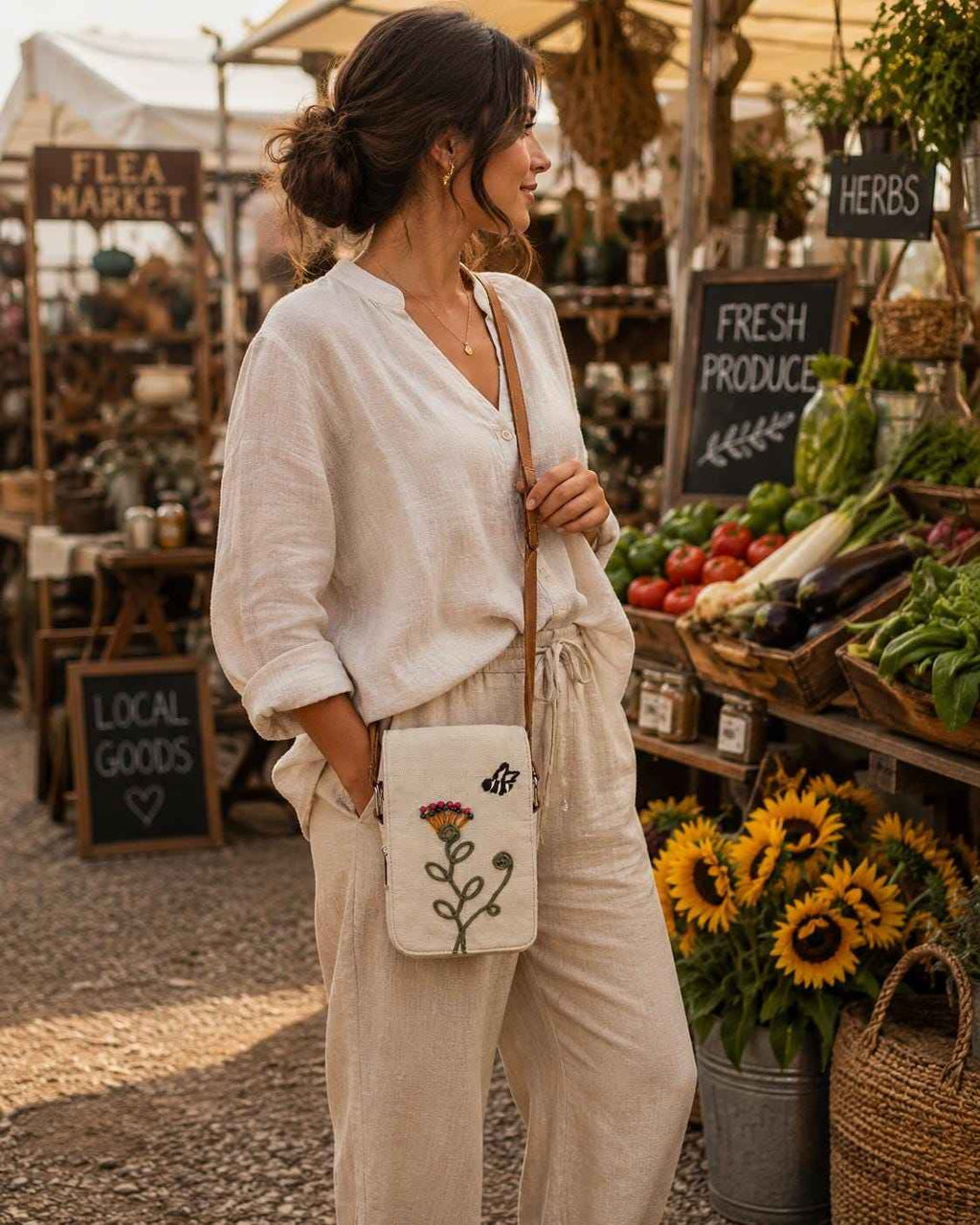 Woman wearing a boho floral crossbody phone pouch with embroidered botanical design and adjustable shoulder strap