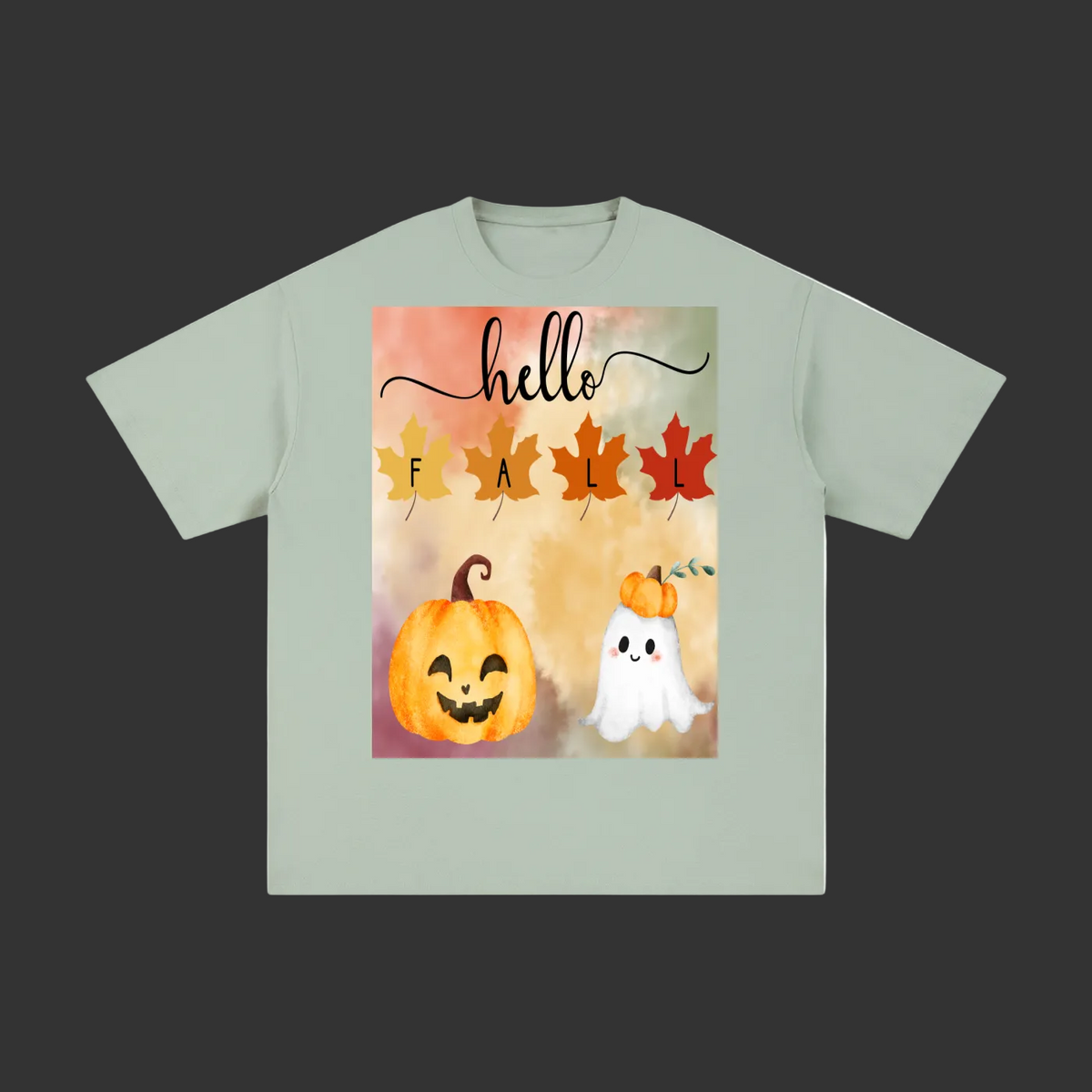 A sage green short-sleeve t-shirt with a colorful autumn-themed graphic on the front. The graphic features the word 'hello' in black script above the letters 'F A L' represented by orange, yellow, and red autumn leaves.