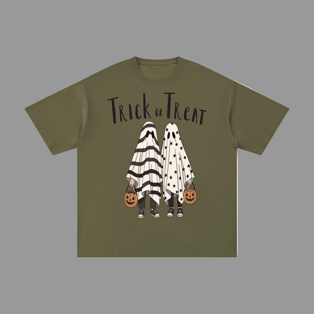 An olive green short-sleeve t-shirt with a 'Trick or Treat' Halloween graphic on the front, featuring two ghost characters in black-and-white and white polka-dot costumes holding jack-o'-lantern buckets, shown on a plain gray background.