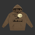 A brown pullover hoodie with a Halloween-themed graphic print on the front, featuring a witch riding a broomstick in front of a full moon, bats, pumpkins, and spooky church silhouettes, shown on a plain gray background.