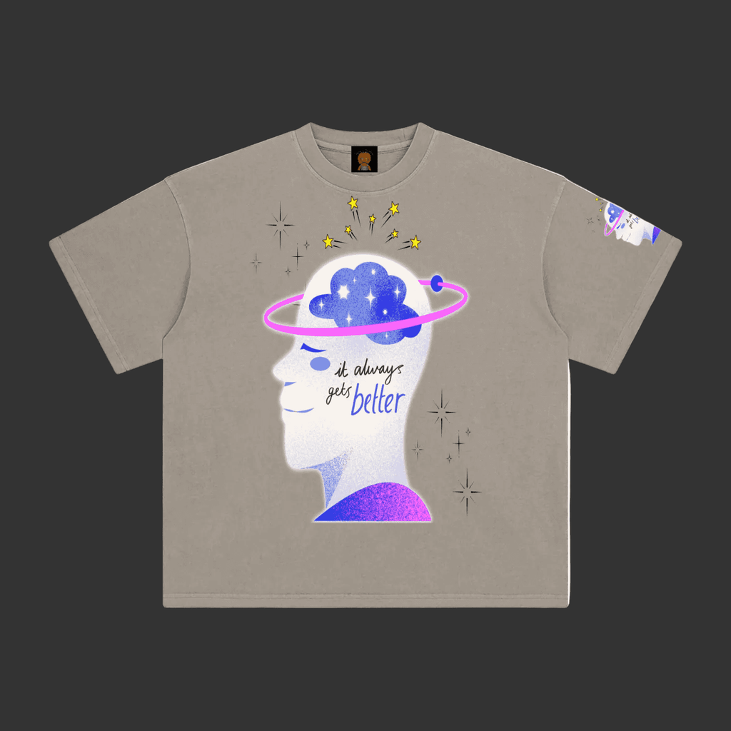 A taupe gray short-sleeve t-shirt with a graphic of a white human head profile showing a blue starry brain, a pink ring, and the text 'it always gets better'.