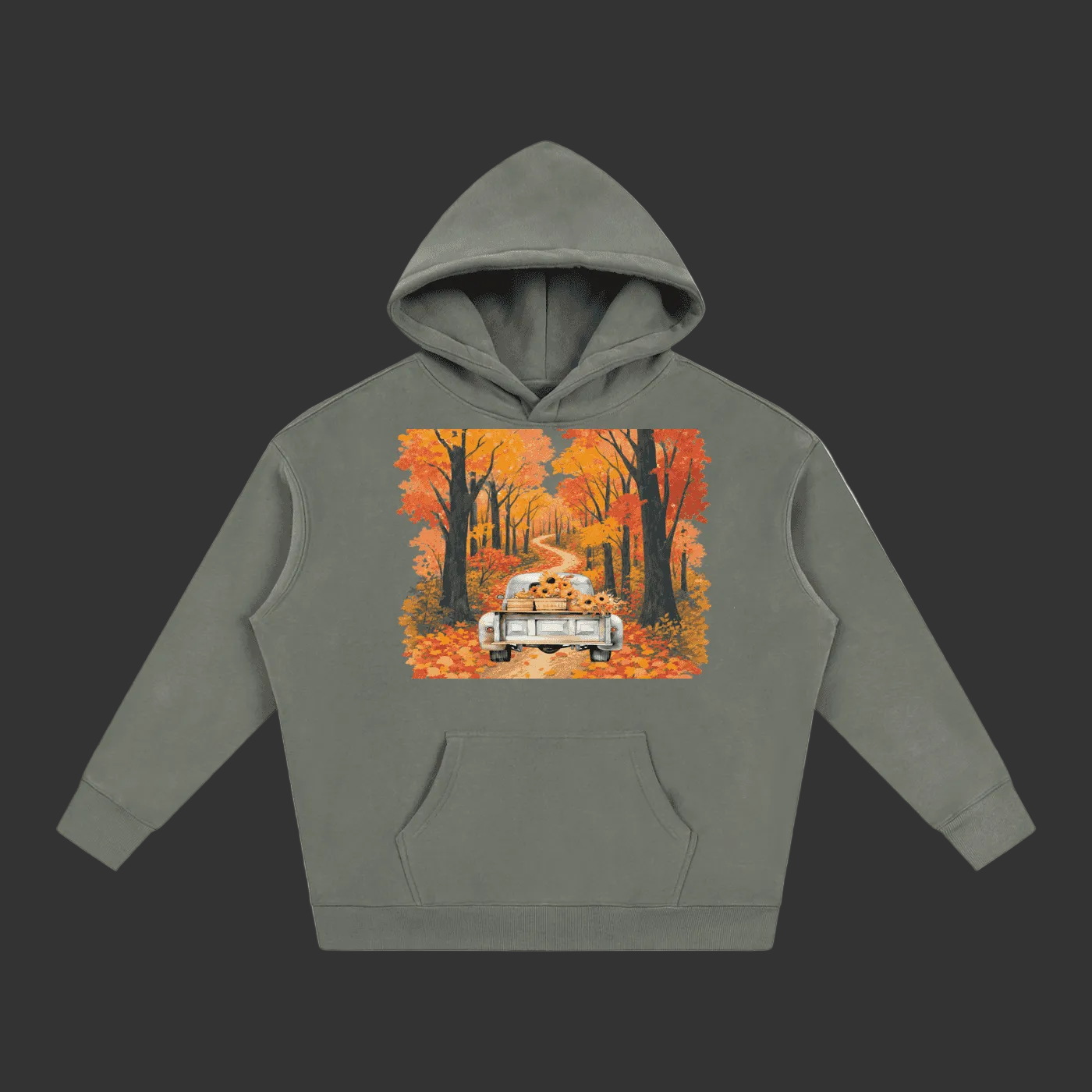 A sage green pullover hoodie with a colorful graphic print on the chest showing a vintage car driving through an autumn forest with a dog in the back seat, displayed on a clean gray background.
