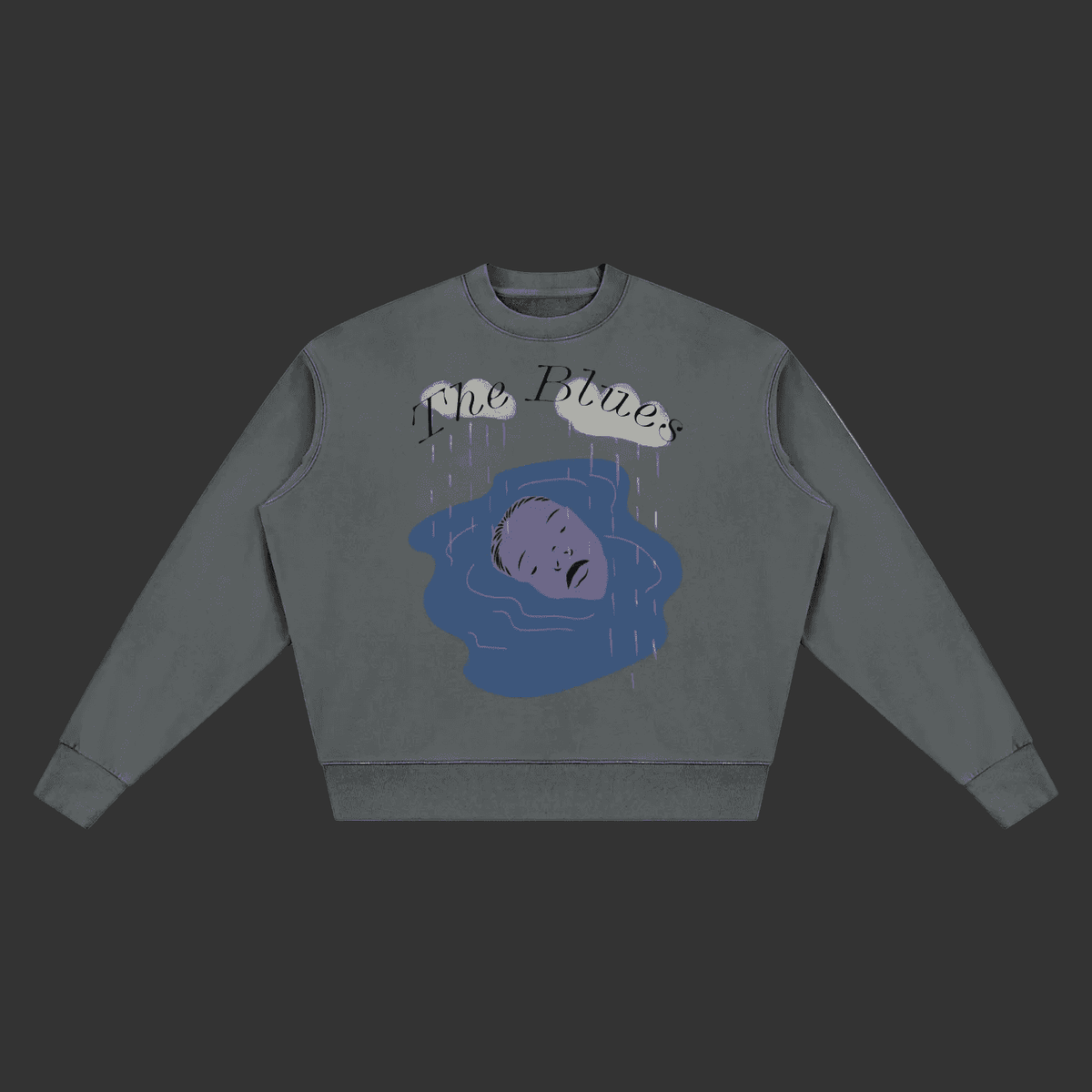 A dark gray crewneck sweatshirt featuring a graphic print of a purple figure in a blue puddle under gray clouds with the text 'The Blues' written above, displayed on a solid gray background.
