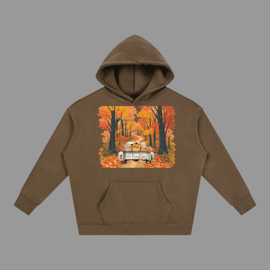 A brown pullover hoodie with a square graphic print on the chest showing a vintage car driving down a road lined with colorful autumn trees. The hoodie is displayed flat against a solid gray background.