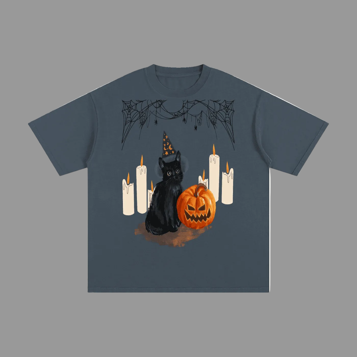 A dark slate blue short-sleeve t-shirt with a Halloween graphic print featuring a black cat in a witch hat, a jack-o'-lantern pumpkin, and white candles, shown on a plain grey background.