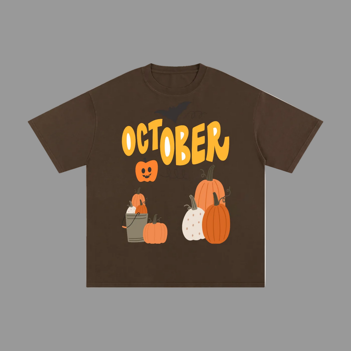 A dark brown short-sleeve t-shirt with a Halloween graphic on the front. The graphic features the word 'OCTOBER' in a wavy yellow font, a jack-o'-lantern, and several pumpkins in orange, white, and brown, along with a small bat silhouette.