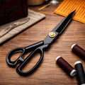 Heavy-duty fabric scissors on wooden worktable with sewing supplies for precise cutting and crafting projects