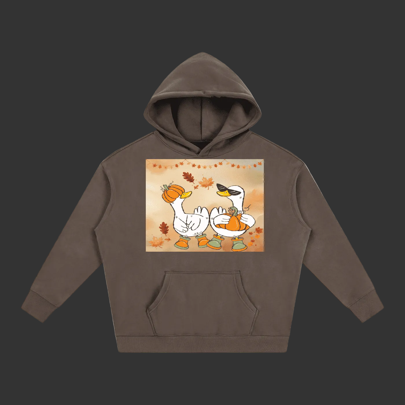 A dark brown pullover hoodie with a front kangaroo pocket and a central graphic print of two cartoon swans holding pumpkins under a warm autumn sky with falling leaves.