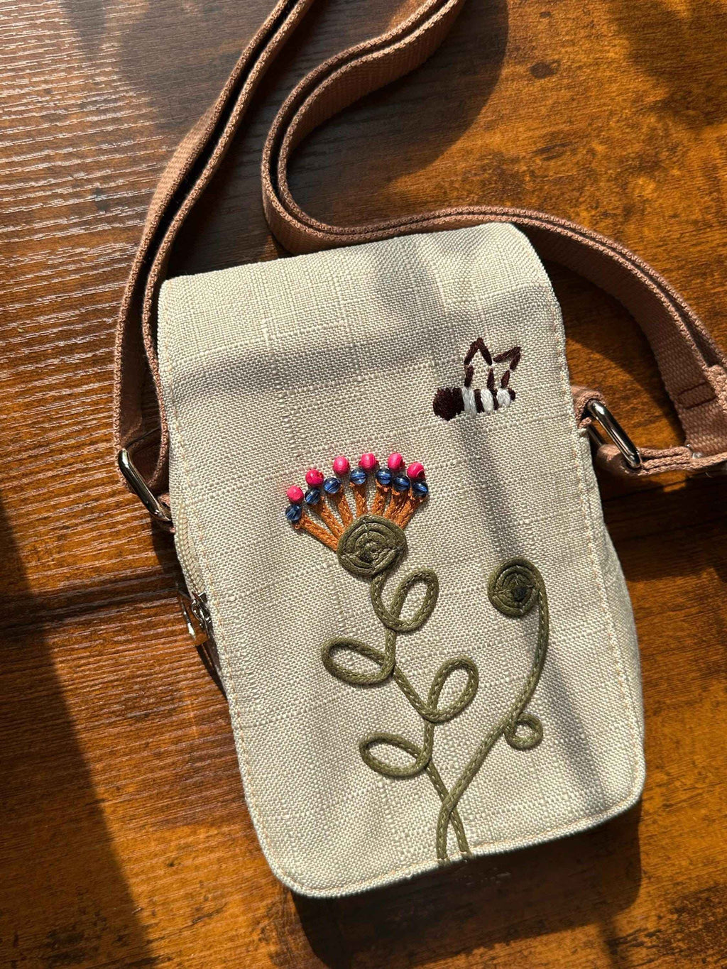 Embroidered floral crossbody phone pouch with adjustable strap and boho-inspired botanical design