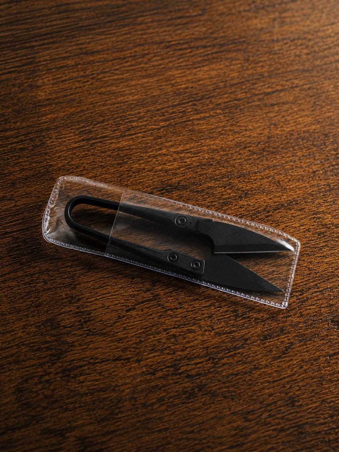U-shape embroidery scissors stored inside protective clear safety case for secure storage