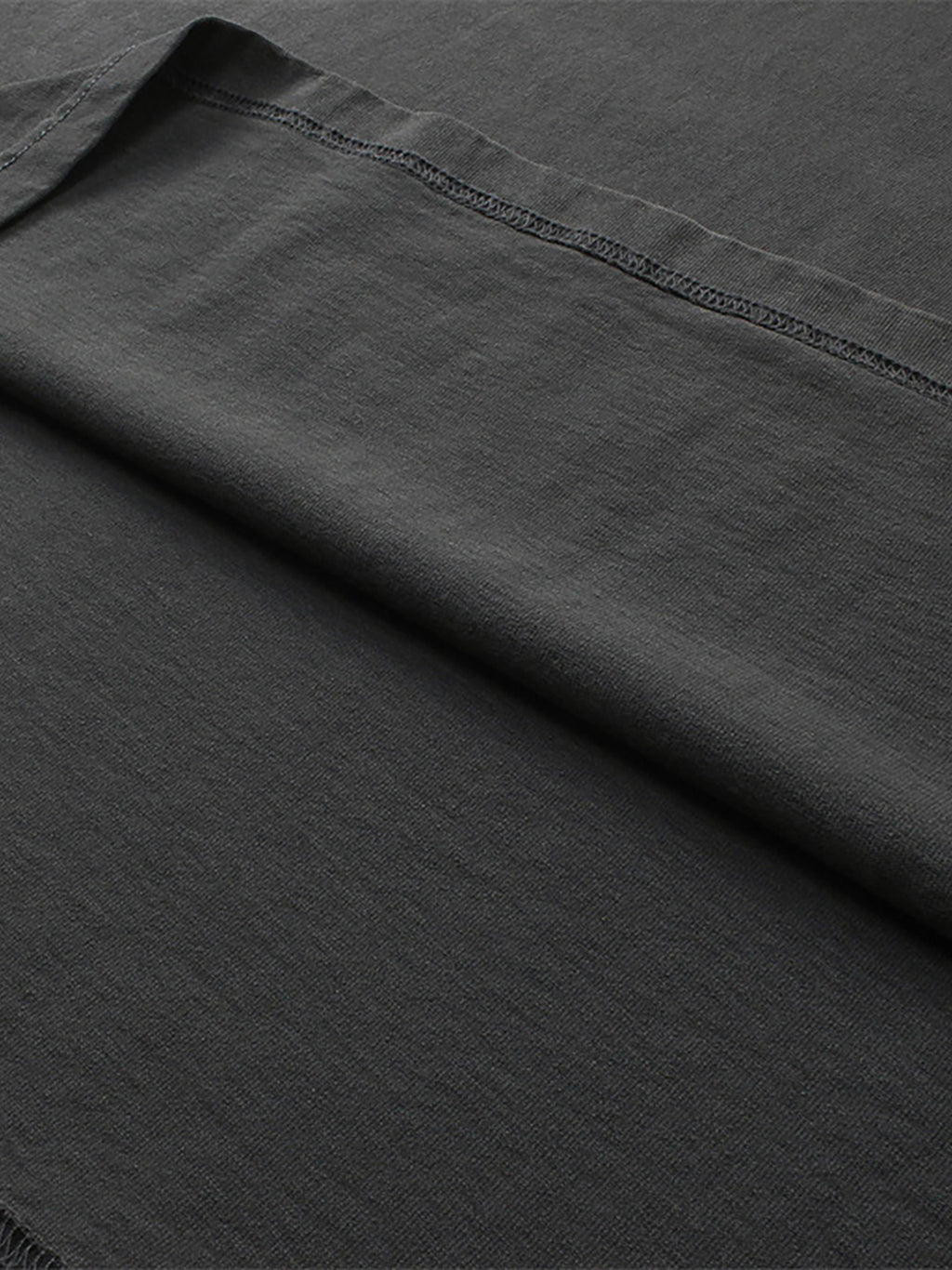 Close-up of dark gray fabric with a visible seam