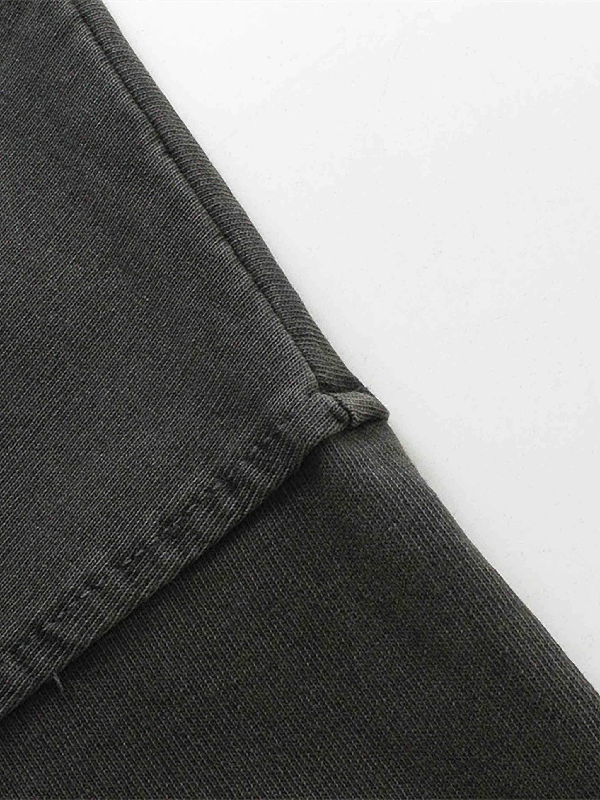Close-up of dark gray pants with a white background