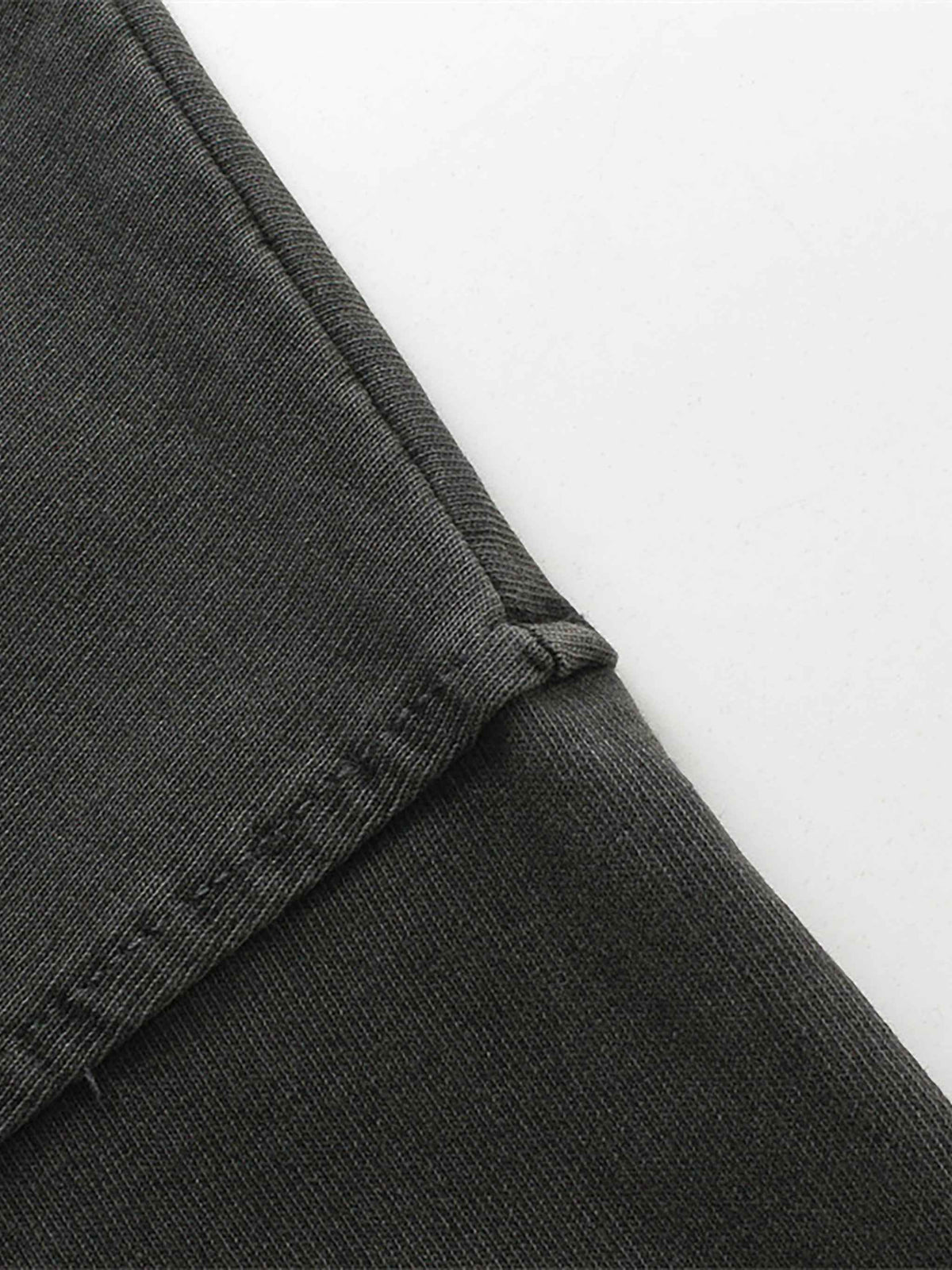 Close-up of dark gray pants with a white background