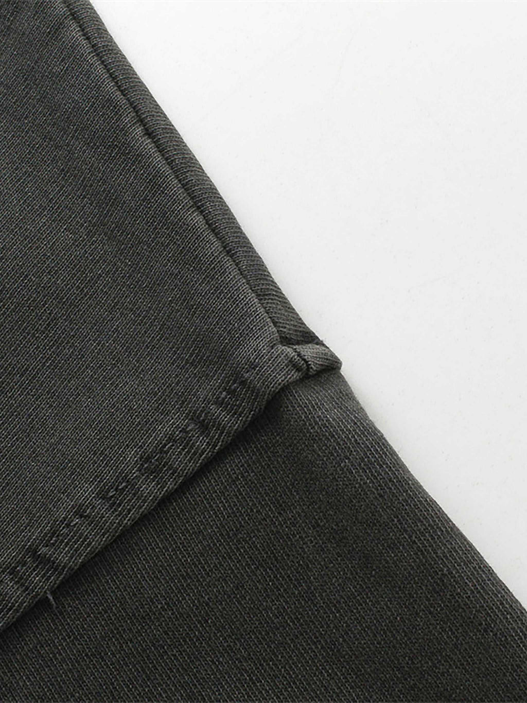 Close-up of dark gray pants with a white background