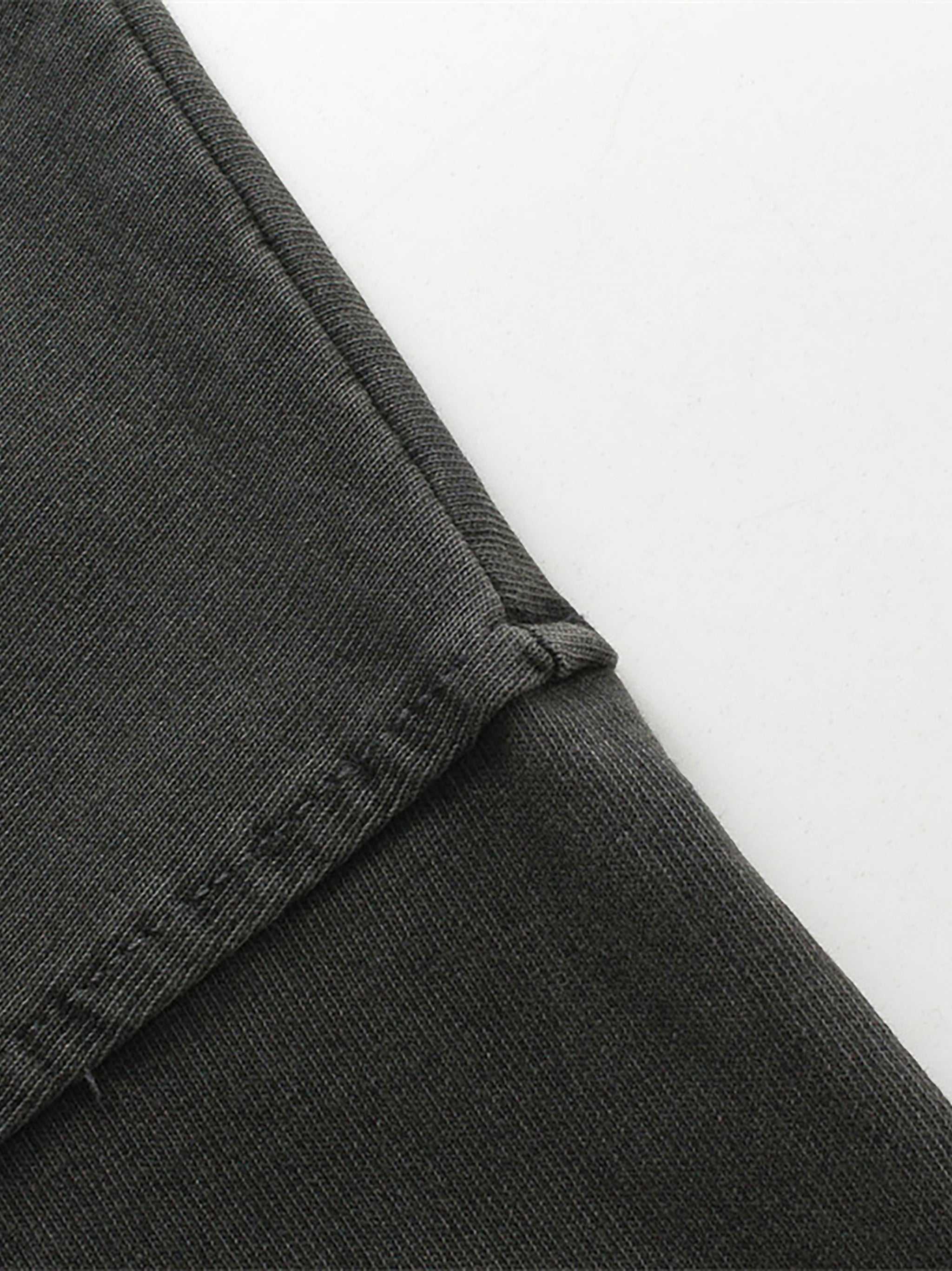 Close-up of dark gray pants with a white background