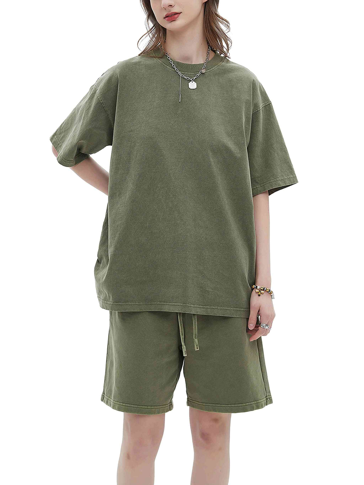 Person wearing an olive green outfit with a t-shirt and shorts on a white background