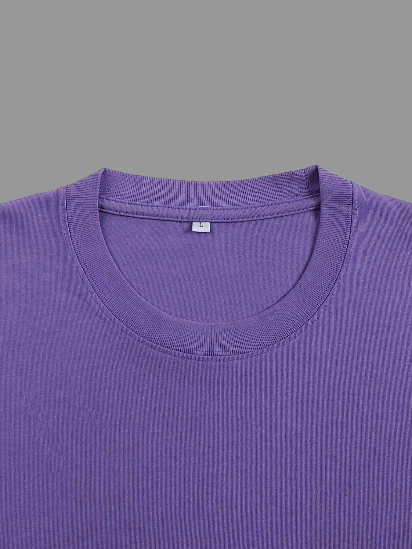 Close-up of a purple crewneck t-shirt showing the inner collar label with a size 'L' tag, on a solid gray background.