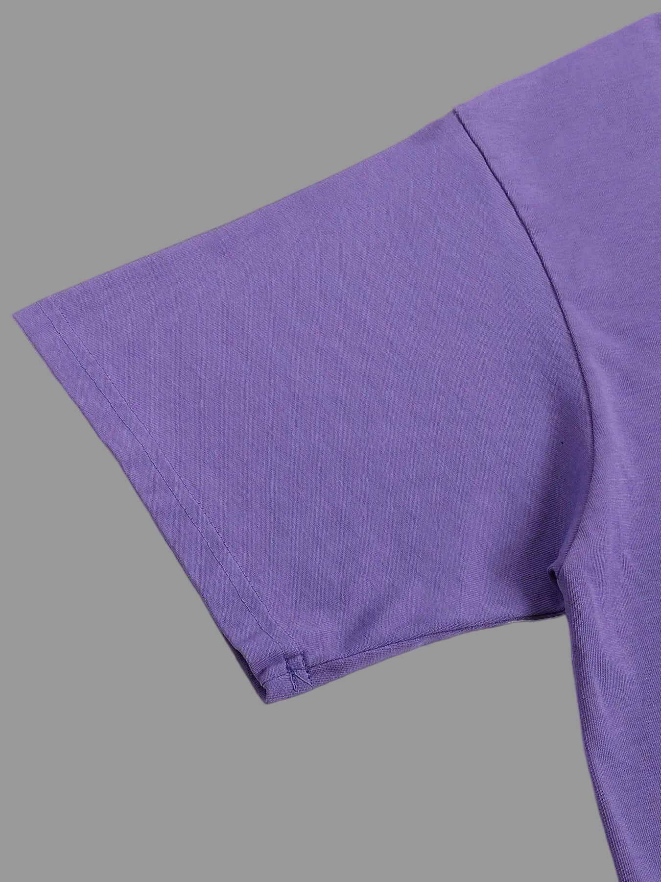 Close-up of a purple fabric texture on a gray background