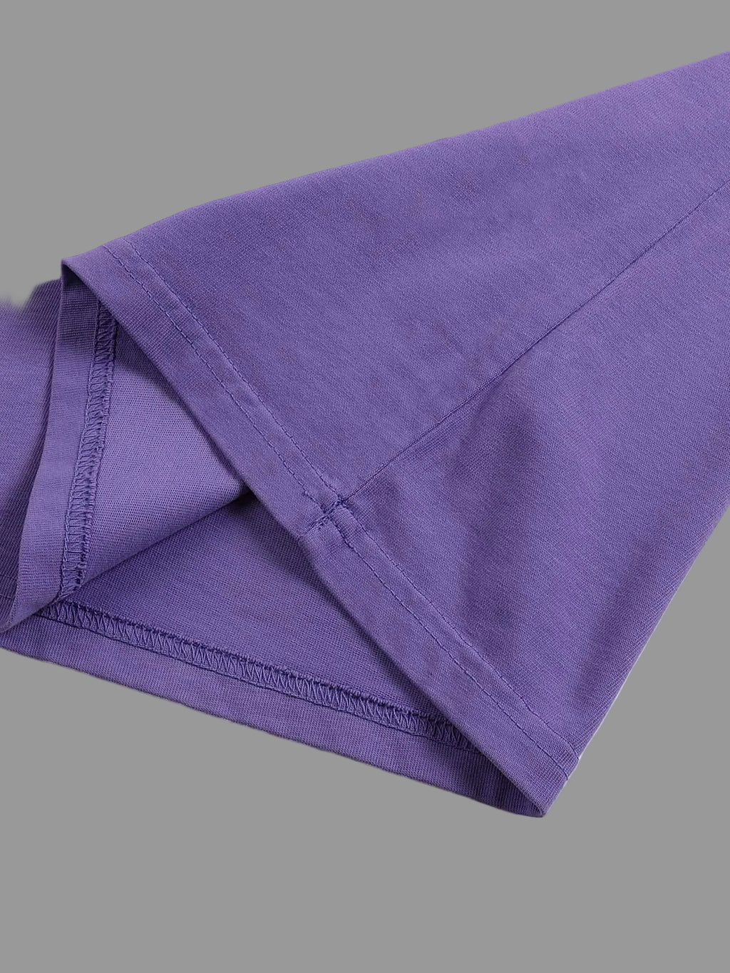 Folded purple fabric on a gray background