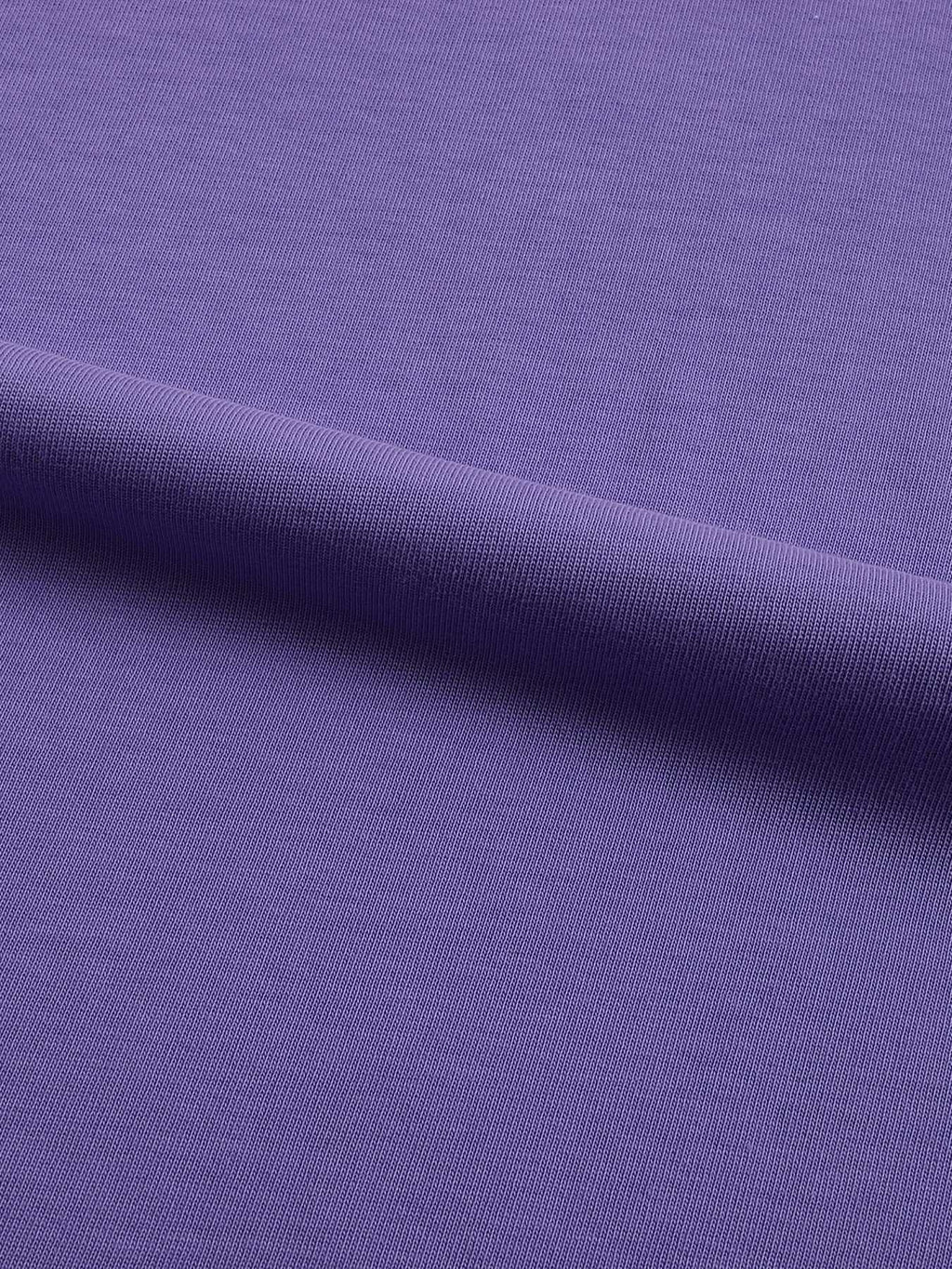A close-up of a purple ribbed knit fabric, showing the texture and a soft diagonal fold.