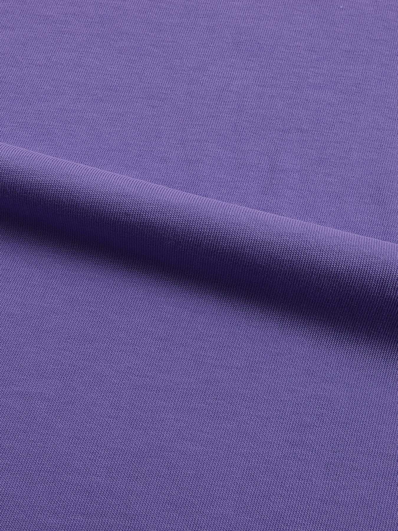 A close-up of a purple ribbed knit fabric, showing the texture and a soft diagonal fold.