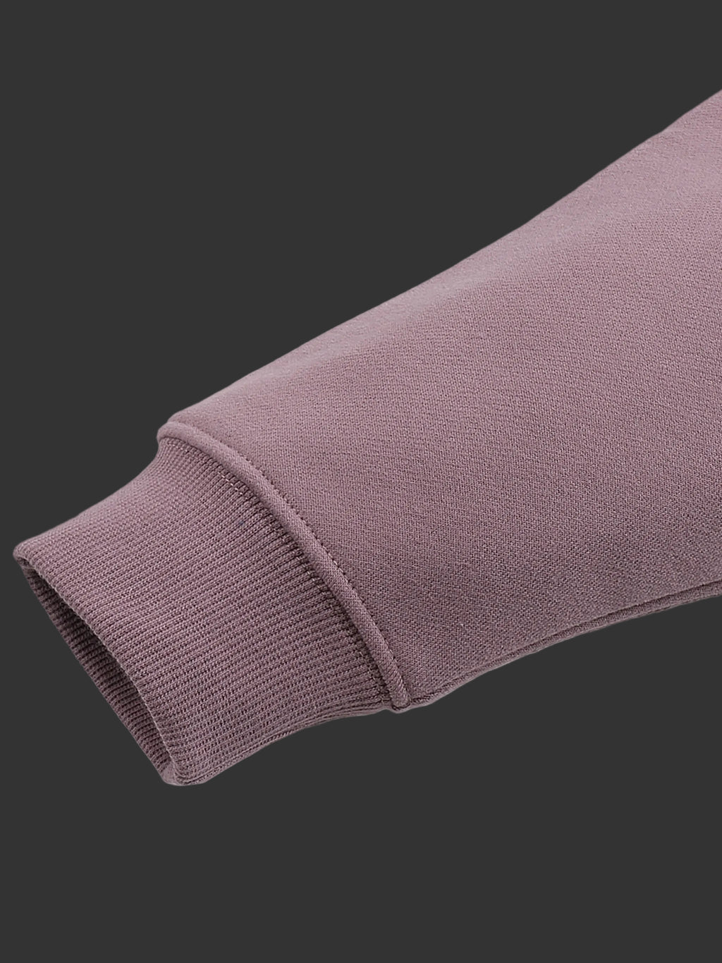 Close-up of a purple sweater sleeve on a gray background