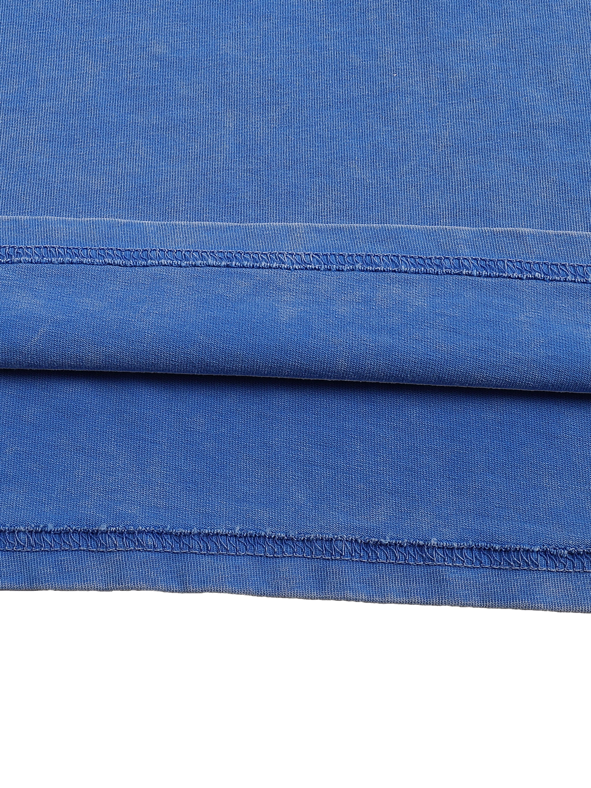 Close-up of blue fabric with a visible seam on a white background