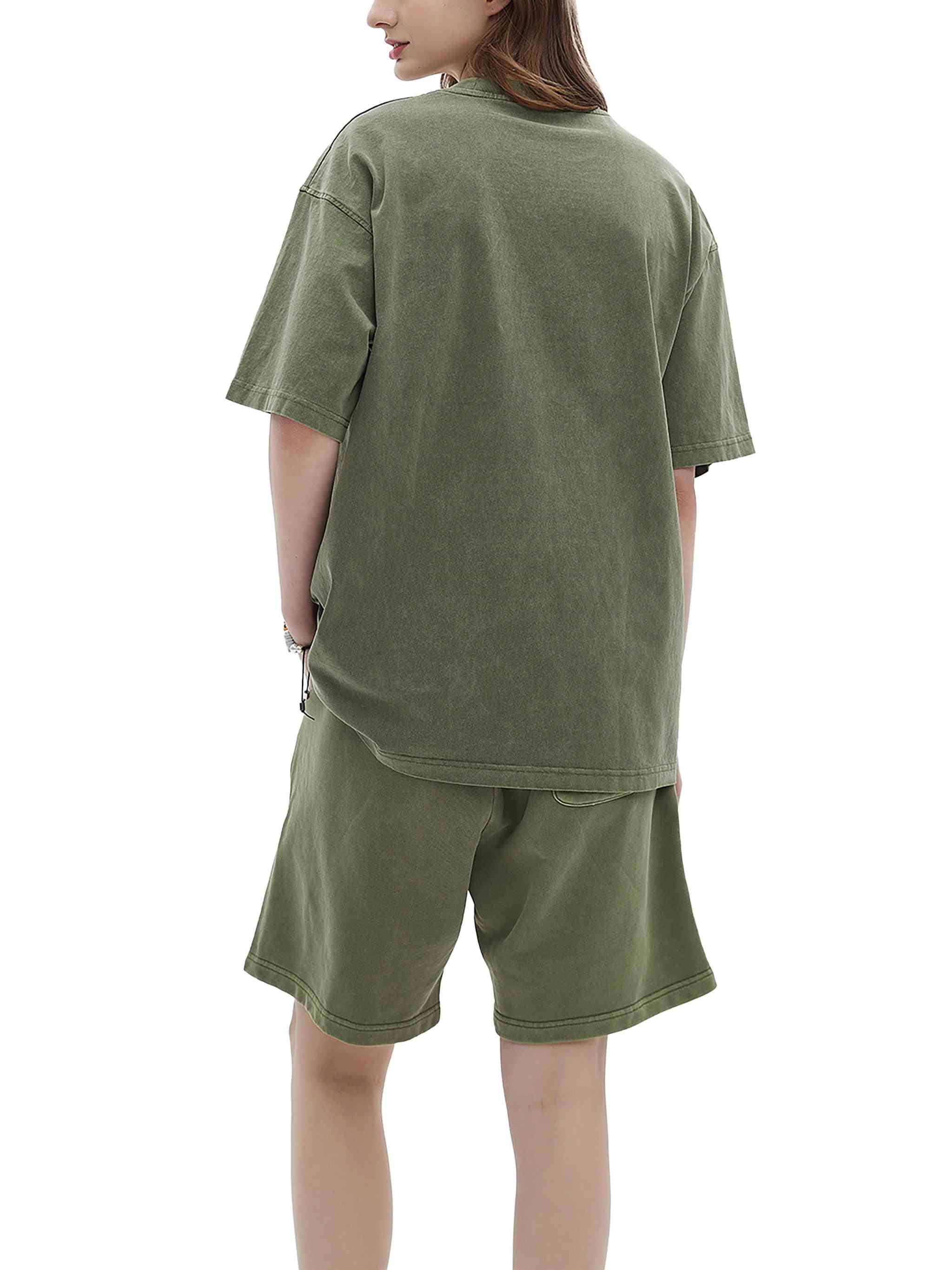 Person wearing an olive green oversized t-shirt and shorts set on a white background