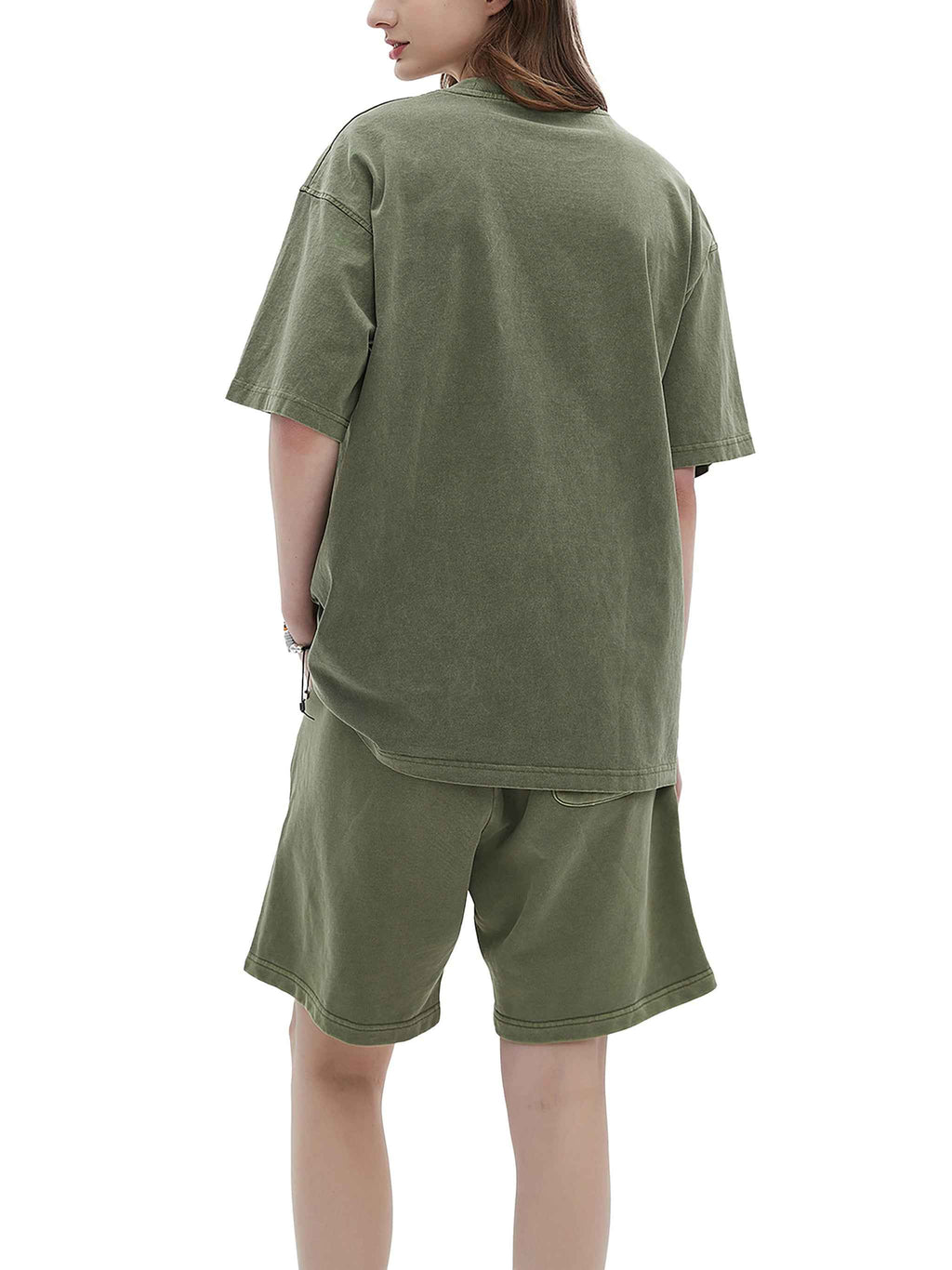 Person wearing an olive green oversized t-shirt and shorts set on a white background