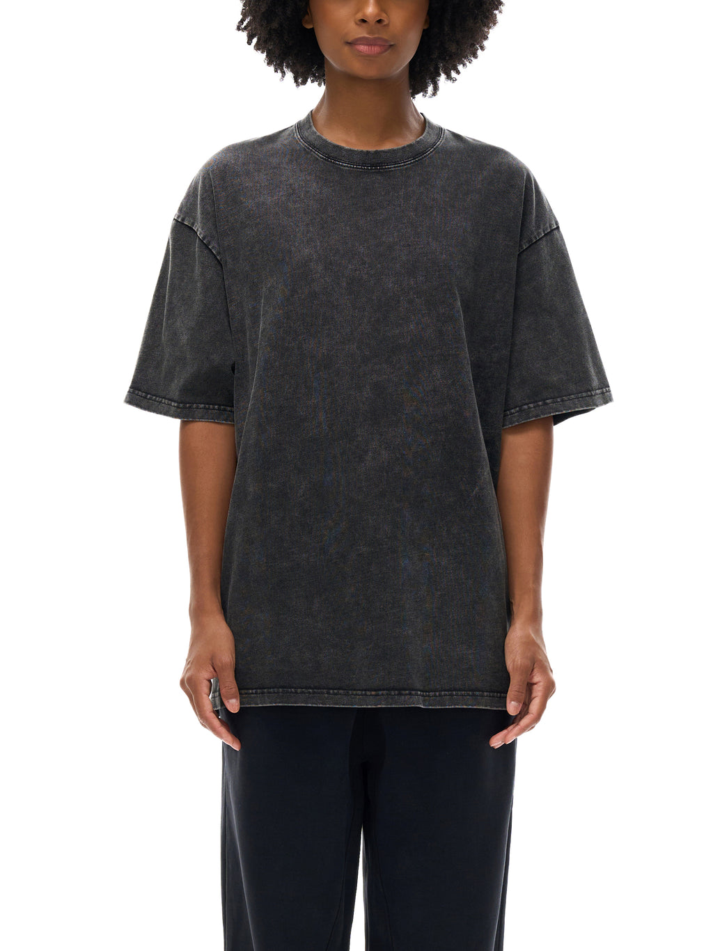 Person wearing a black acid-wash t-shirt on a white background