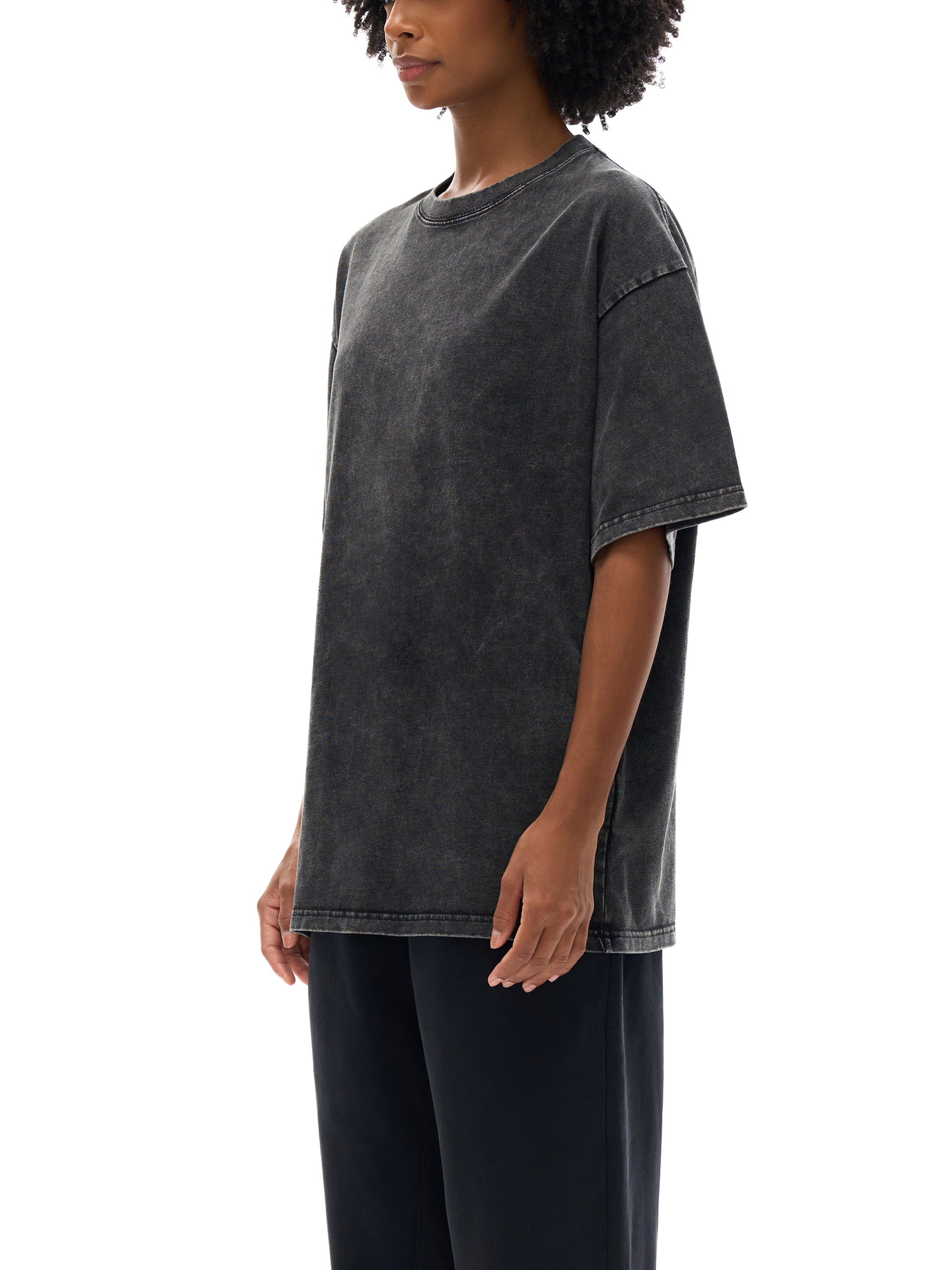 Person wearing a black oversized t-shirt on a white background
