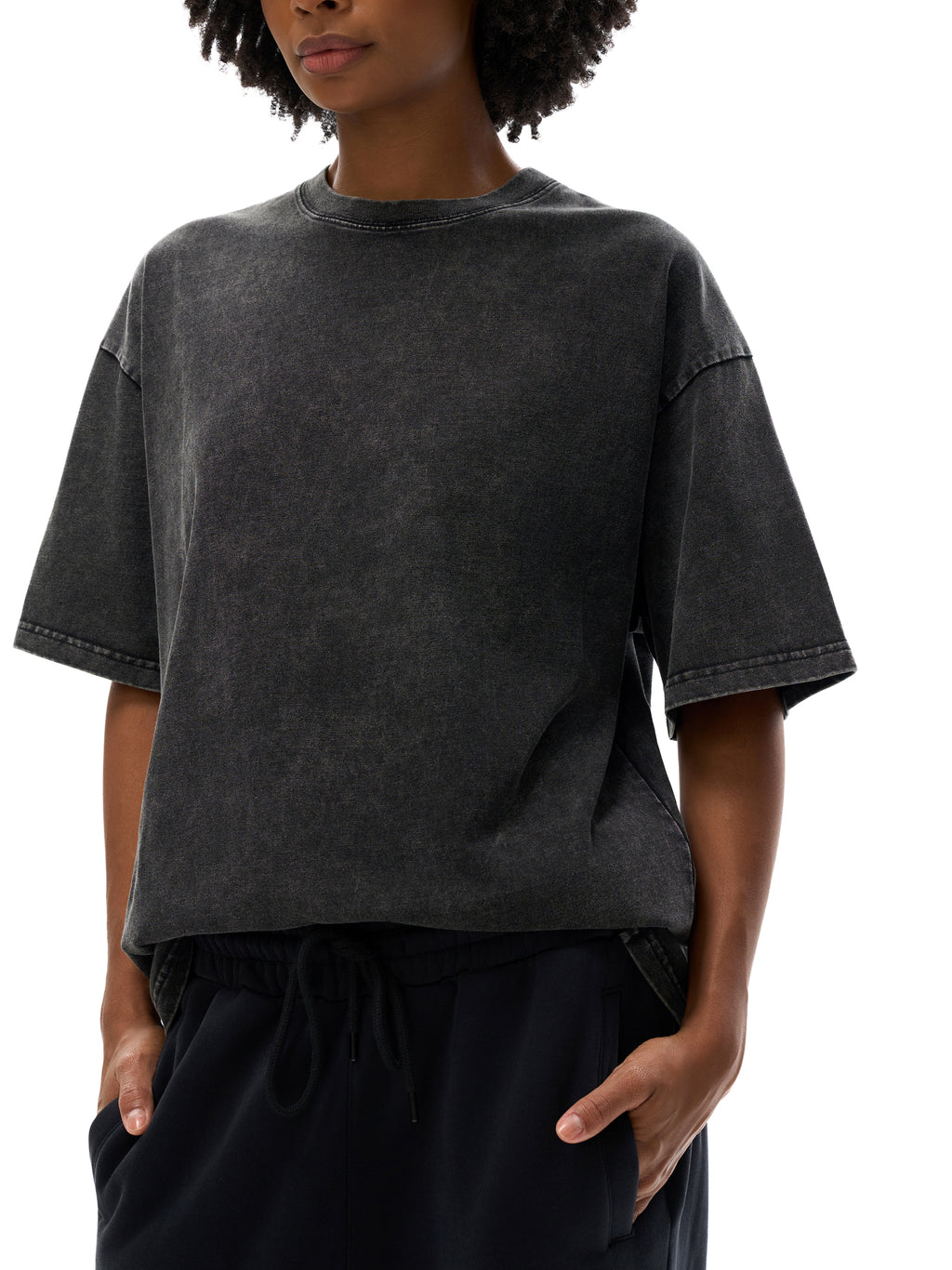 Person wearing a dark gray t-shirt and black pants on a white background