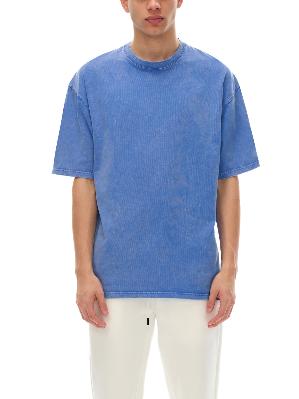 Person wearing a blue t-shirt and white pants on a white background