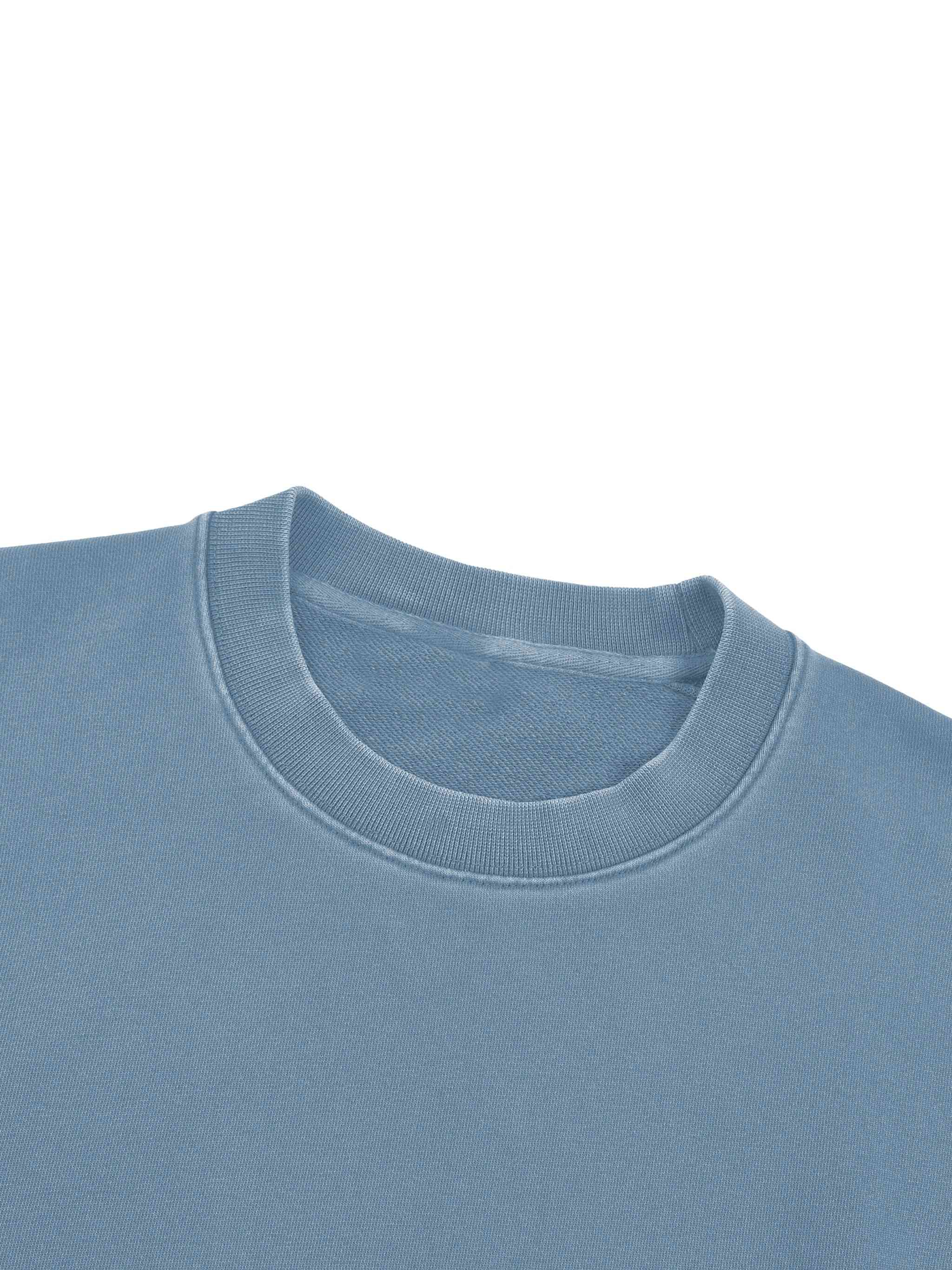 Close-up of a light blue crewneck sweatshirt showing the ribbed collar and inner neck label against a plain white background.