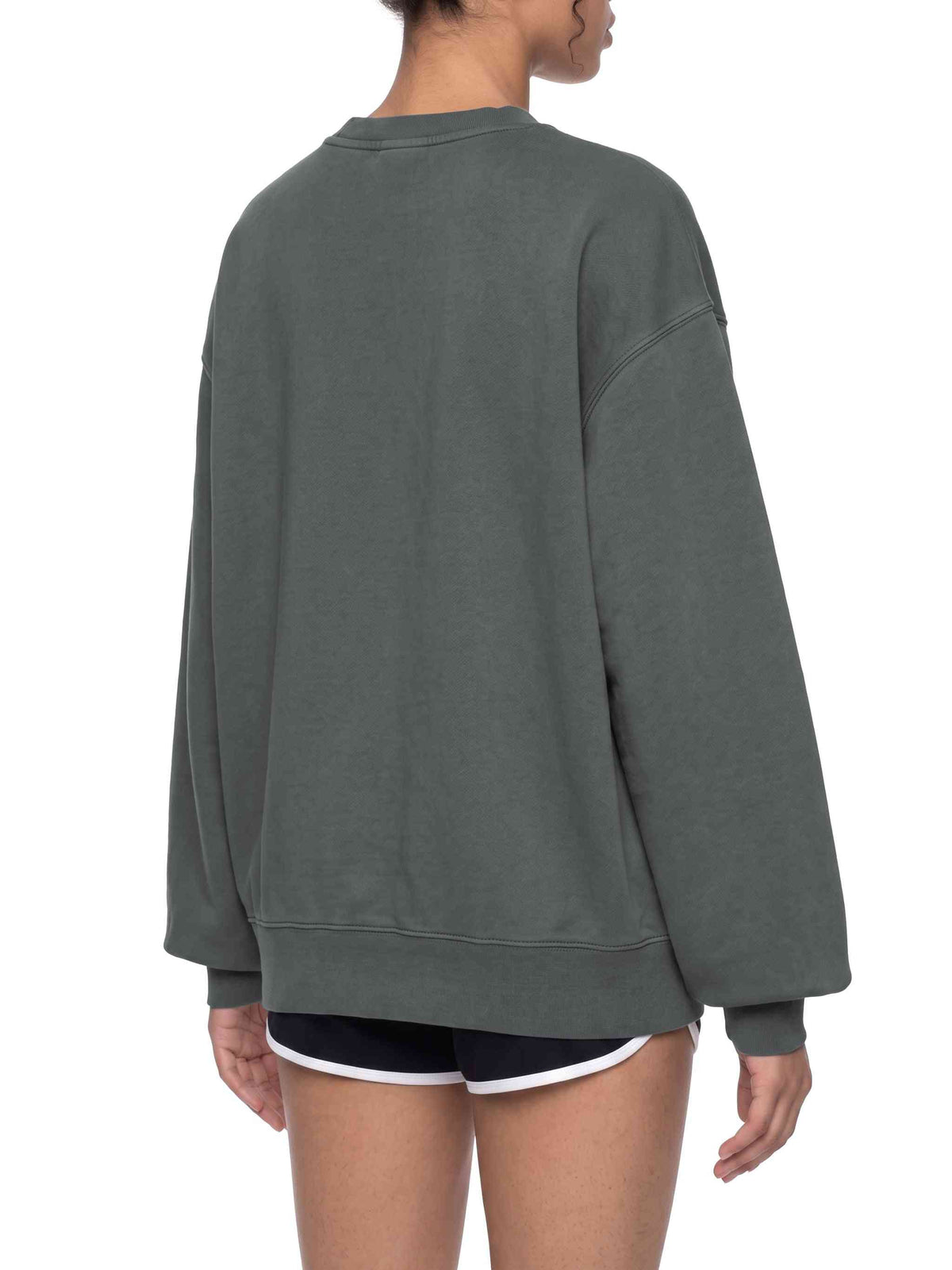 A person shown from the back wearing an oversized dark gray crewneck sweatshirt and black athletic shorts with a white trim, against a plain white background.